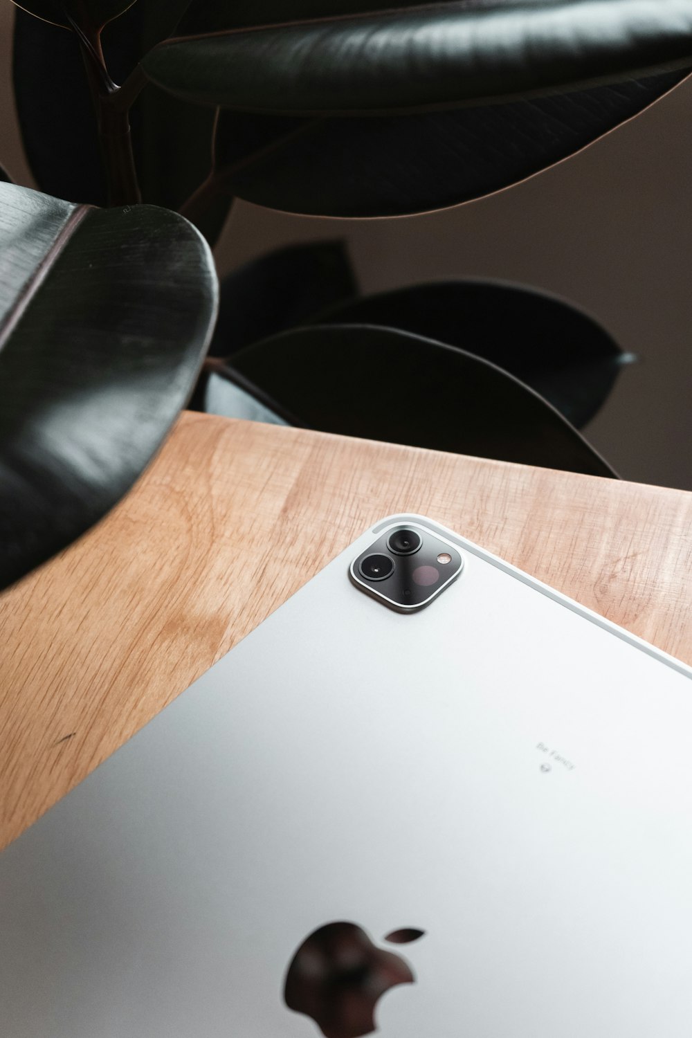 an apple laptop sitting on top of a wooden table