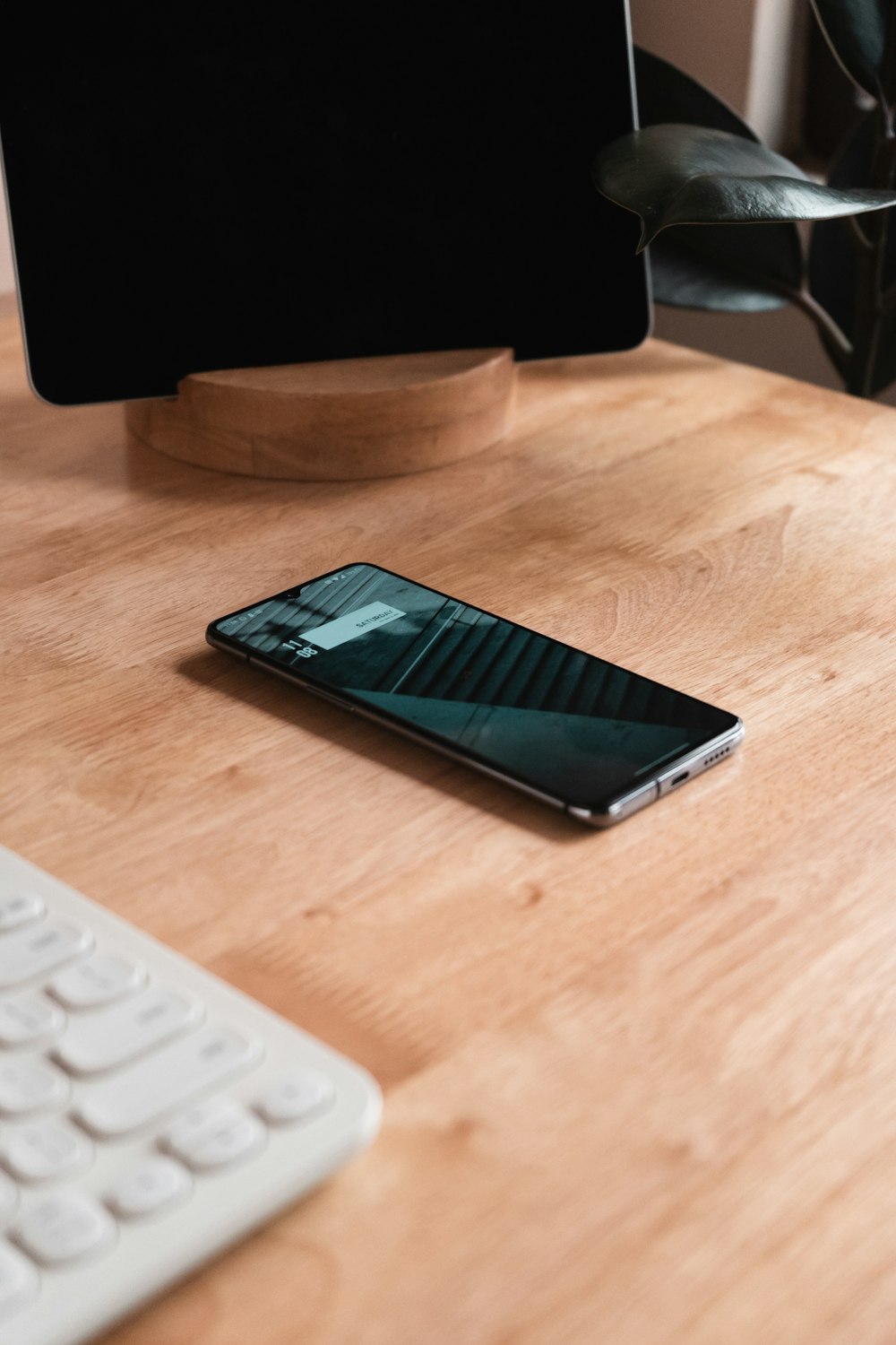 a cell phone sitting on top of a wooden desk