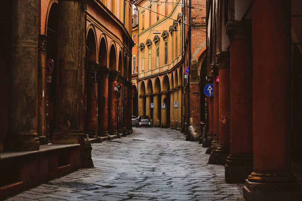 a narrow city street with a clock tower in the background