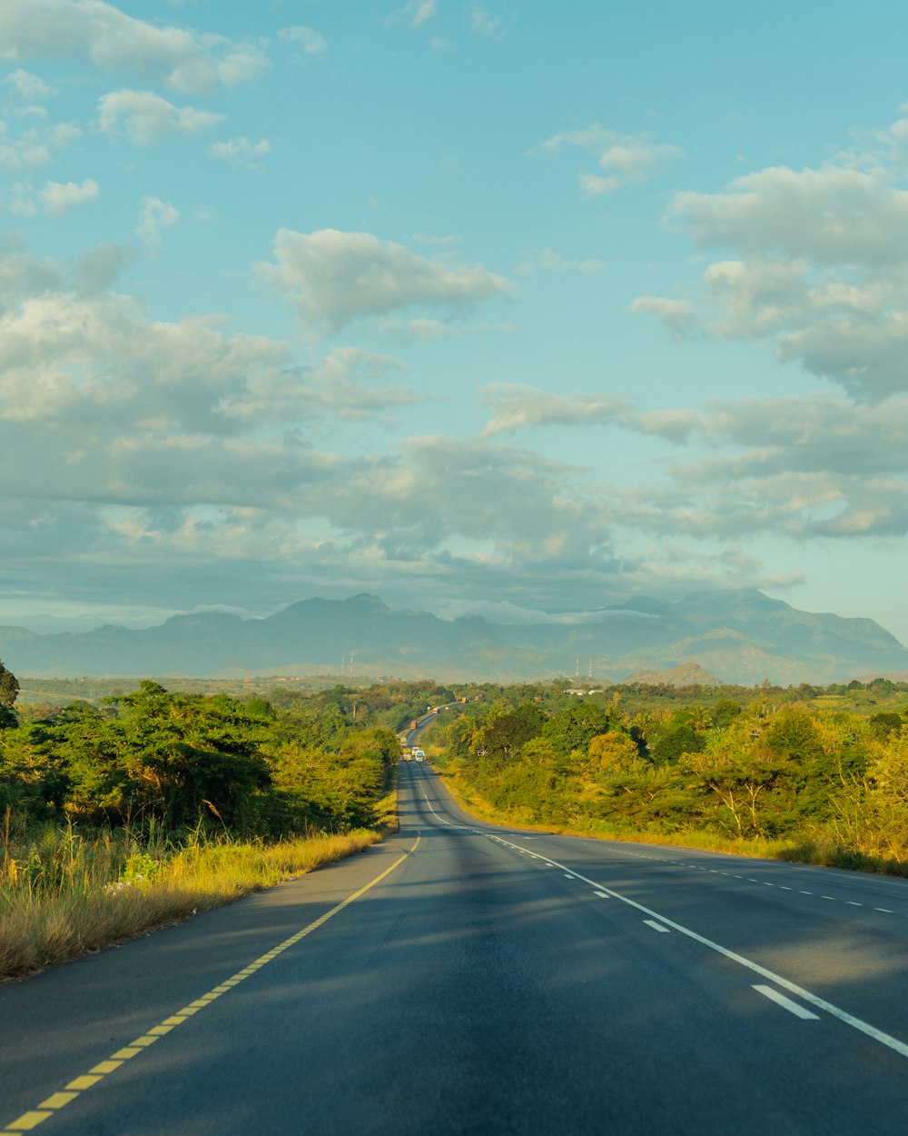 an empty road with a mountain in the distance