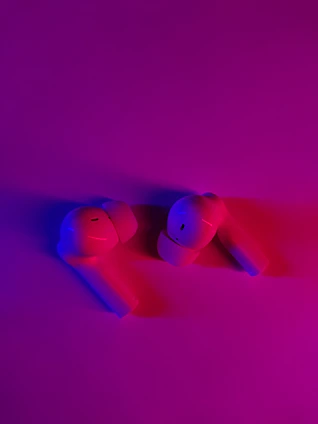 A futuristic wireless earbud set glowing with electric blue light against a dark background