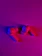 Close-up of a stylish neon blue silicone AirPods cover glowing softly against a dark background.