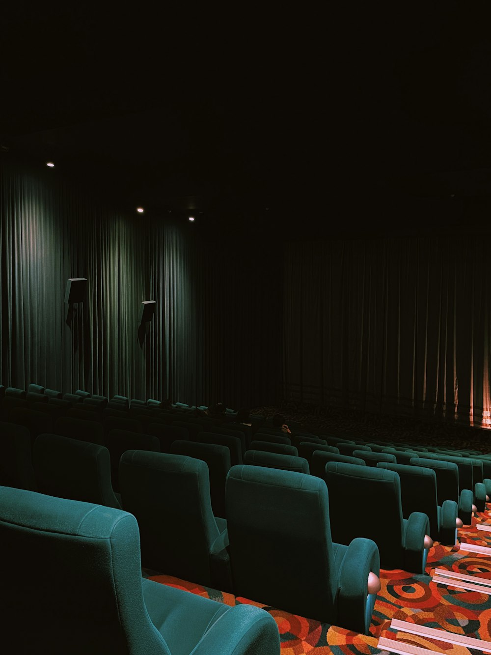 a row of chairs sitting in front of a theater screen