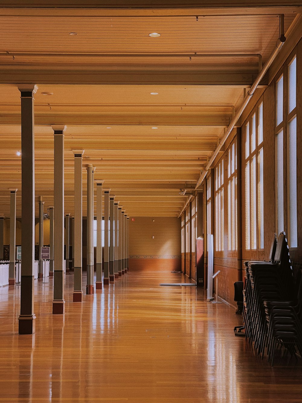 una grande stanza con molte finestre e pavimenti in legno
