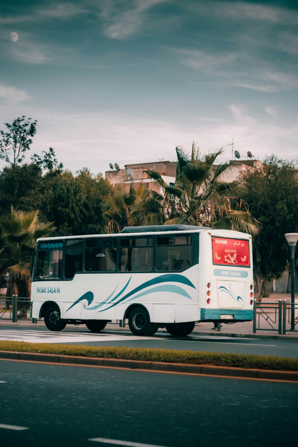 a blue and white bus parked on the side of the road