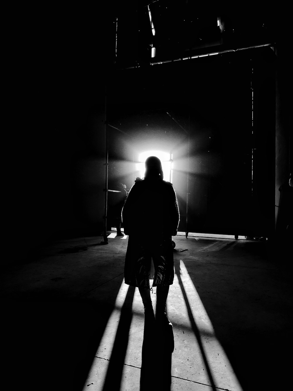 a person standing in a dark room with a suitcase