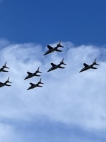 A group of model aircraft flying in a clear blue sky.