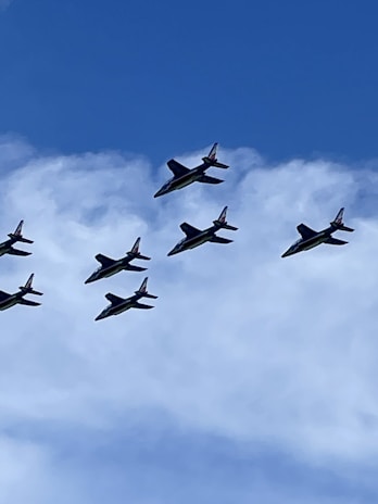 A group of drones flying in formation against a clear blue sky