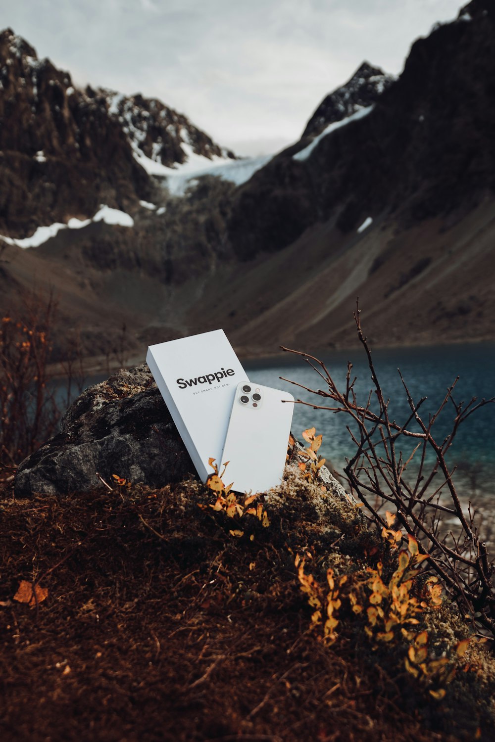 a refrigerator sitting on top of a mountain next to a lake