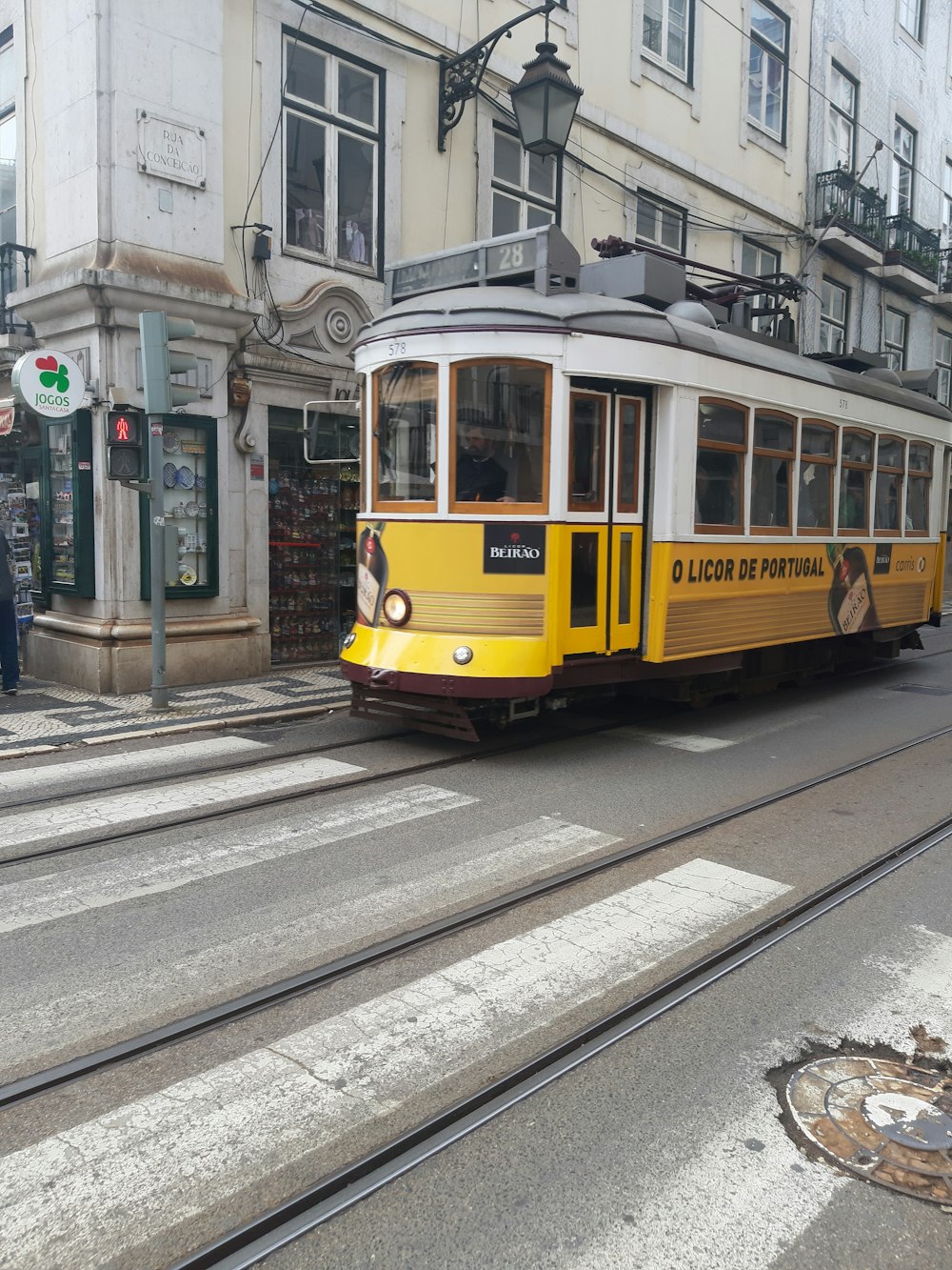 a yellow and white trolley on a city street