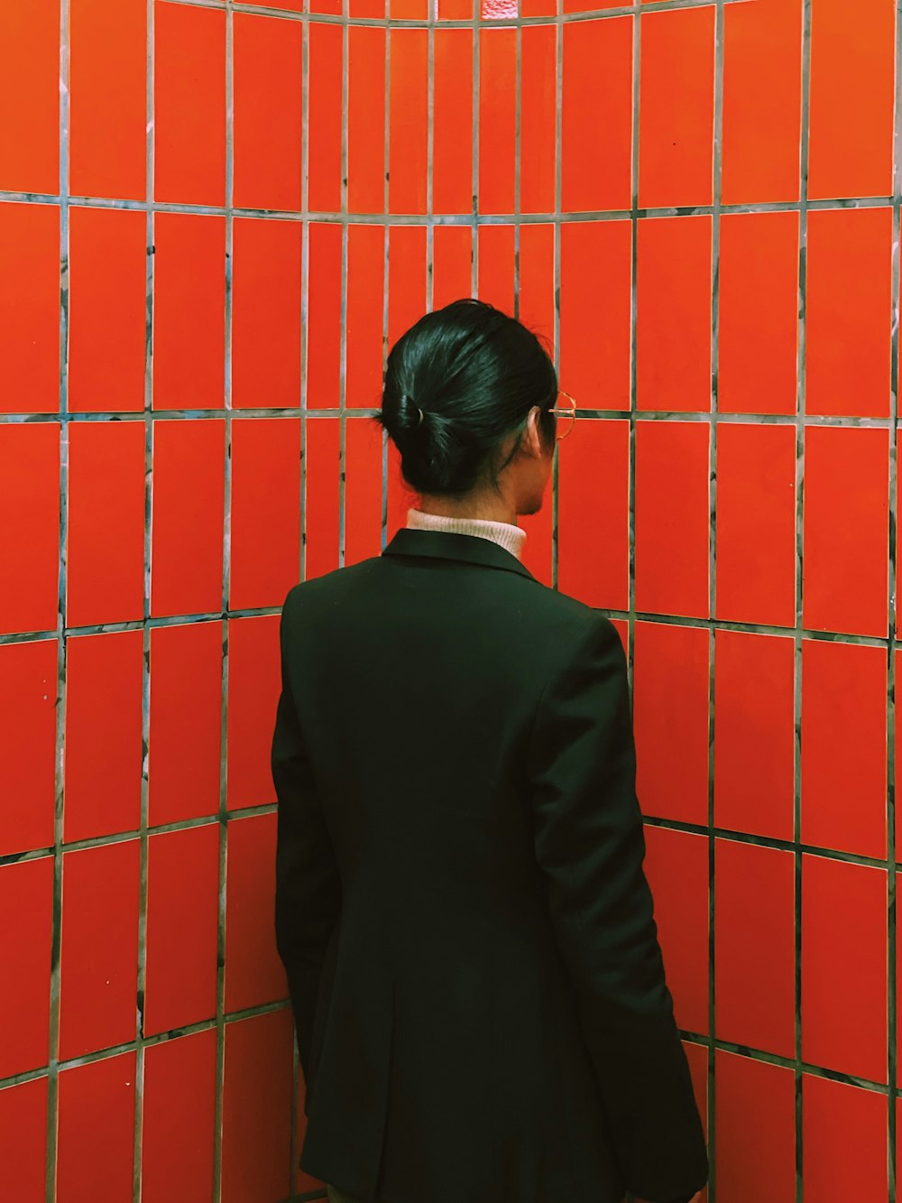 a woman standing in front of a red wall