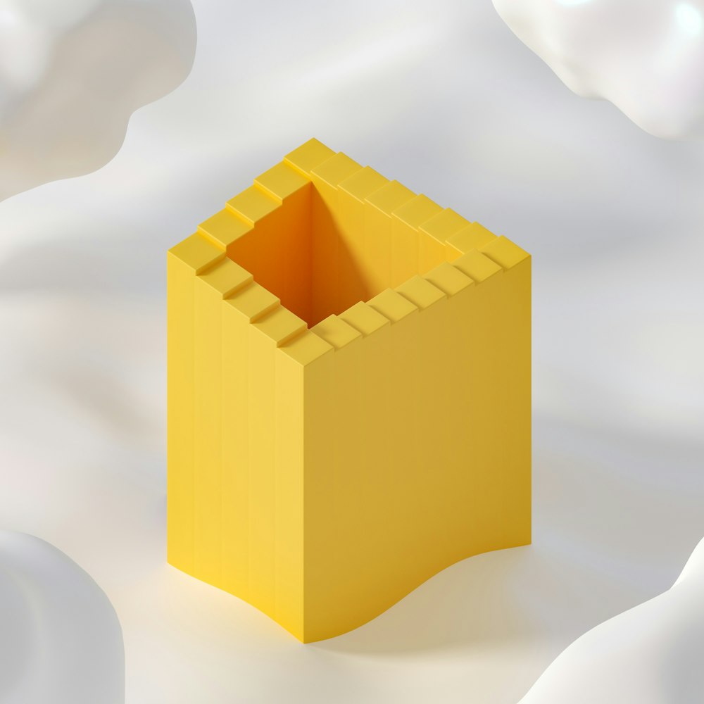 um objeto amarelo com um fundo branco