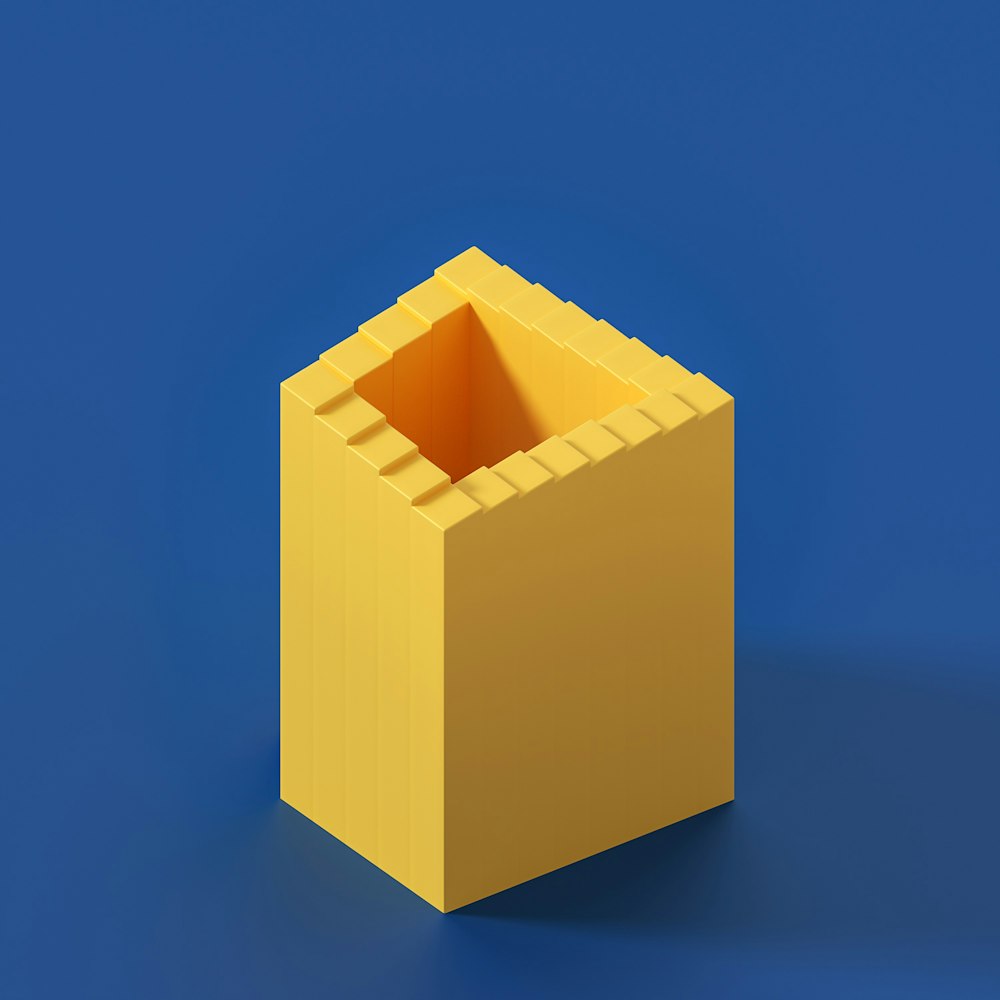 une boîte jaune avec une ouverture carrée sur fond bleu