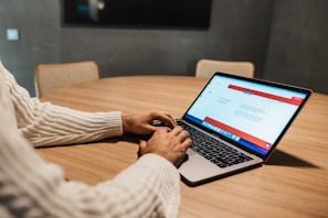 a person sitting at a table with a laptop