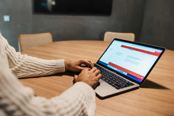 A business owner reviewing a website design on a laptop during a meeting.