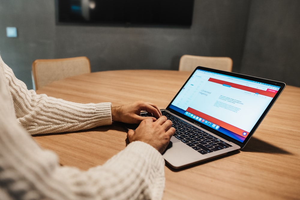 a person sitting at a table with a laptop