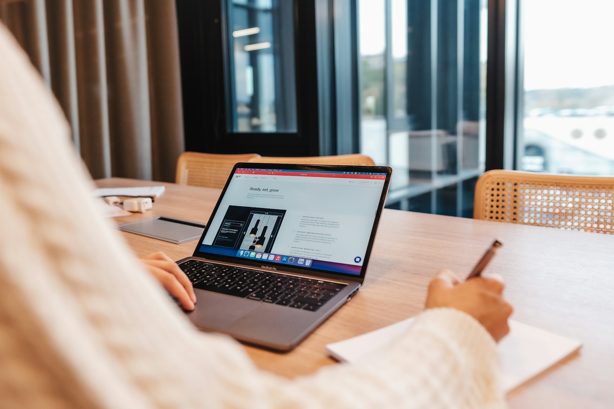 A man working on his laptop computer in an office viewing Zyro website