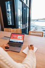 a person sitting at a table with a laptop
