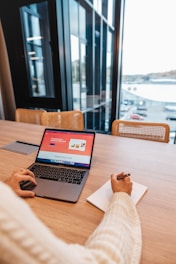 a person sitting at a table with a laptop