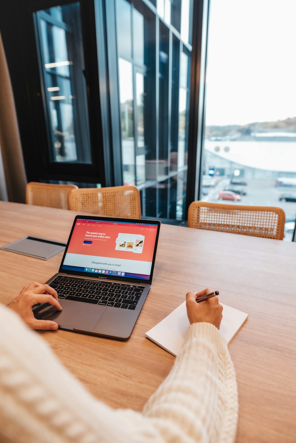 a person sitting at a table with a laptop