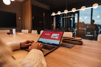 a person sitting at a table with a laptop