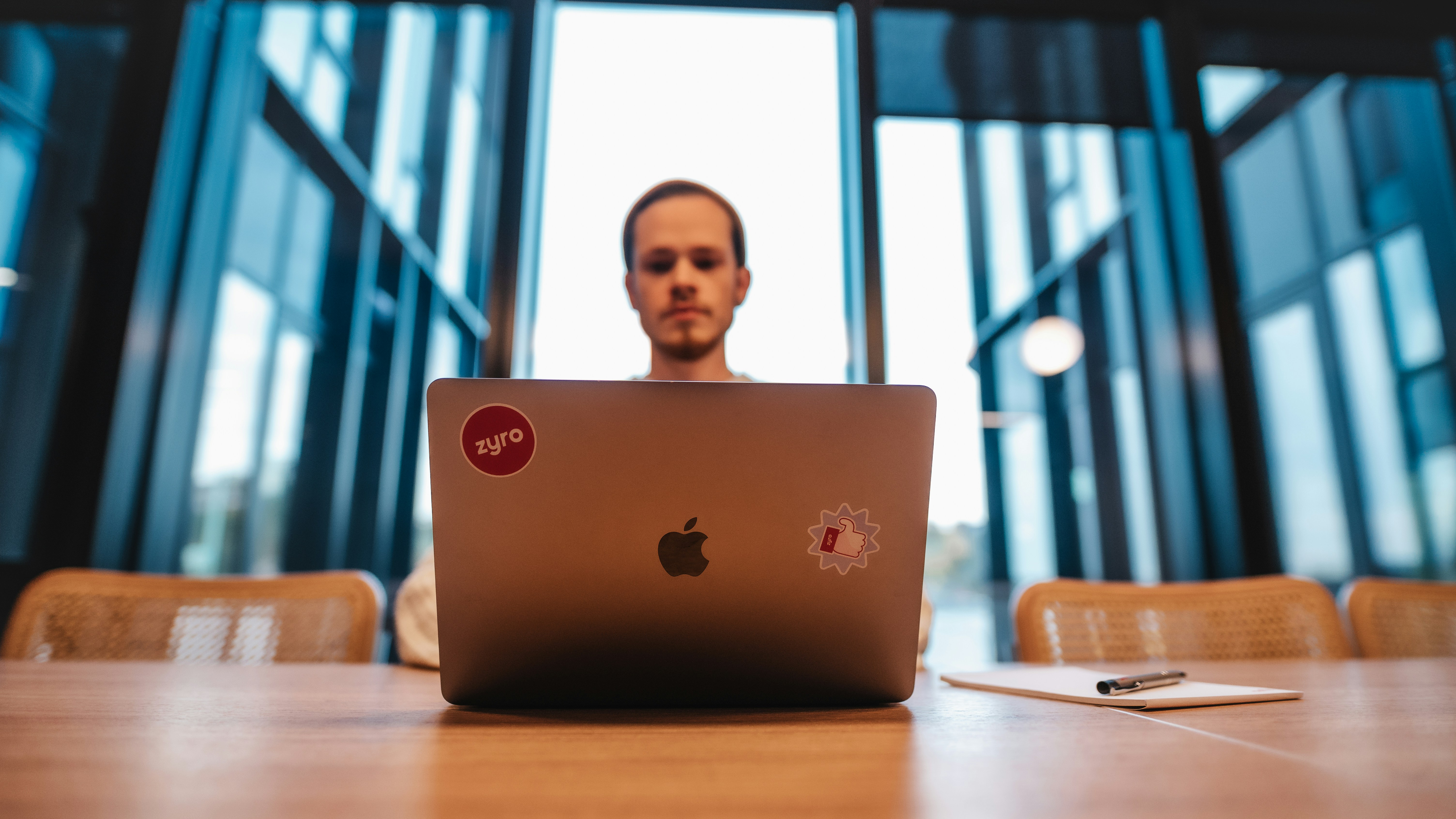 A laptop computer in front of a man in an office space