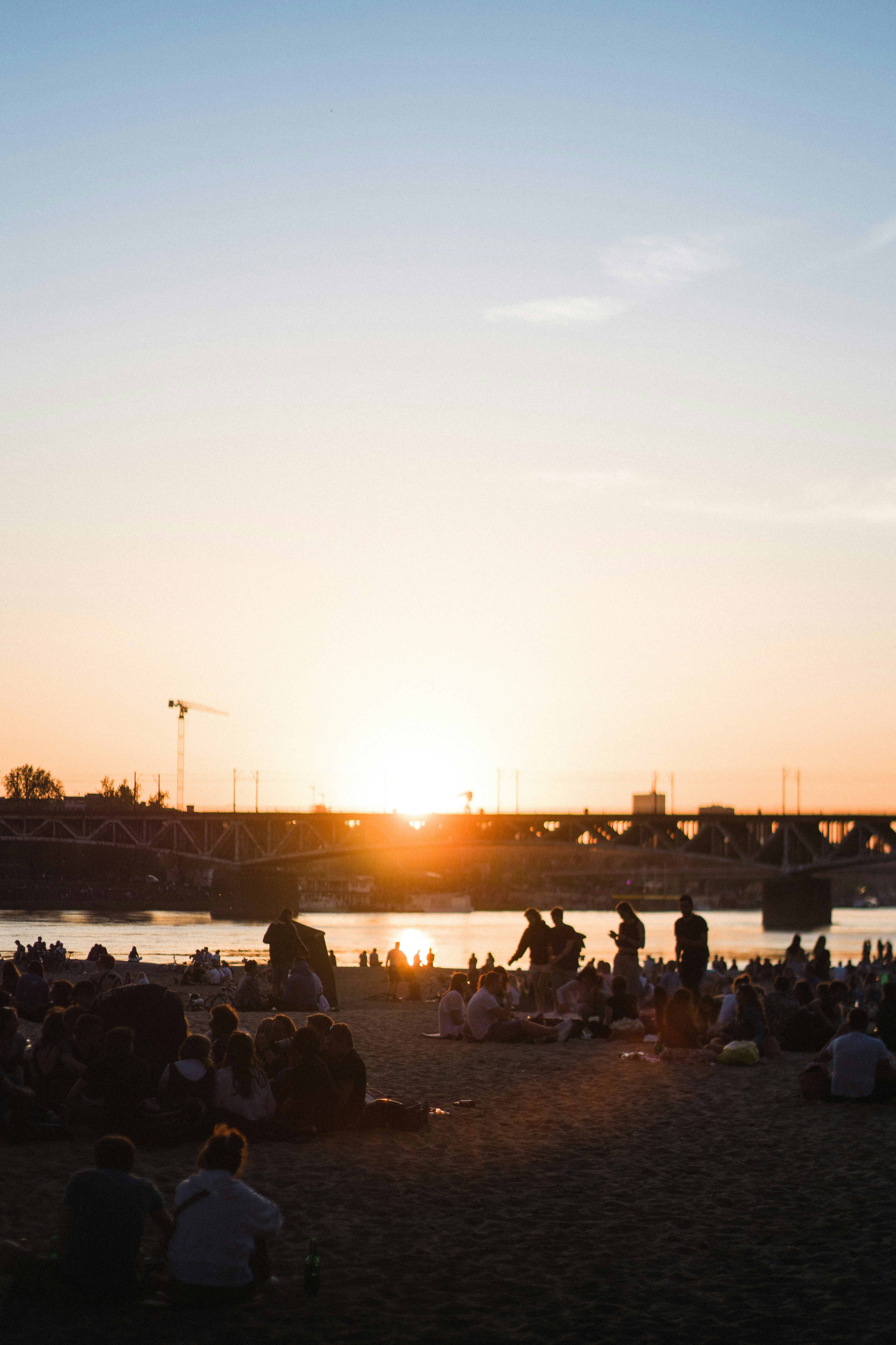 a group of people sitting on top of a sandy beach