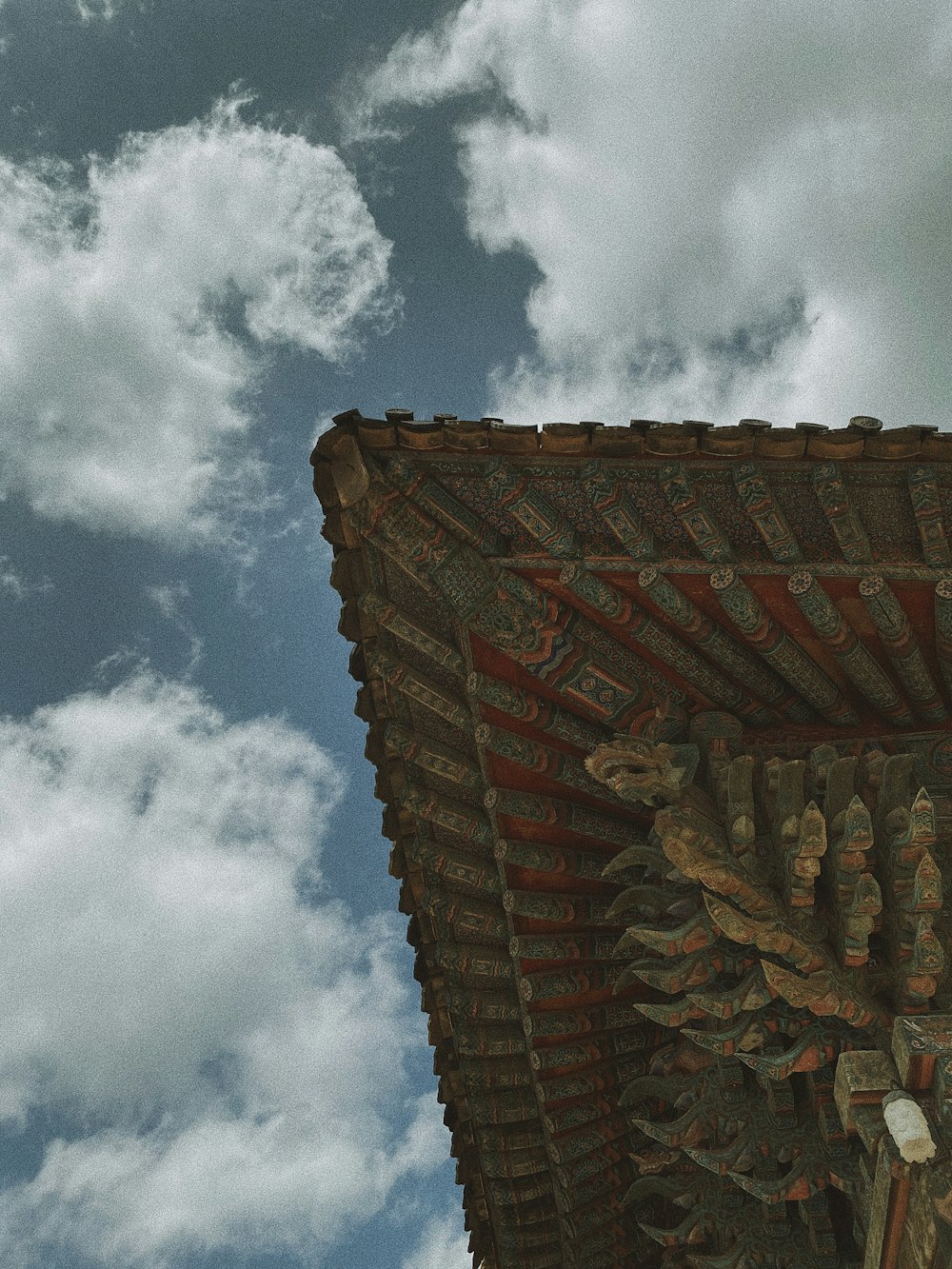 a clock on the side of a building under a cloudy sky