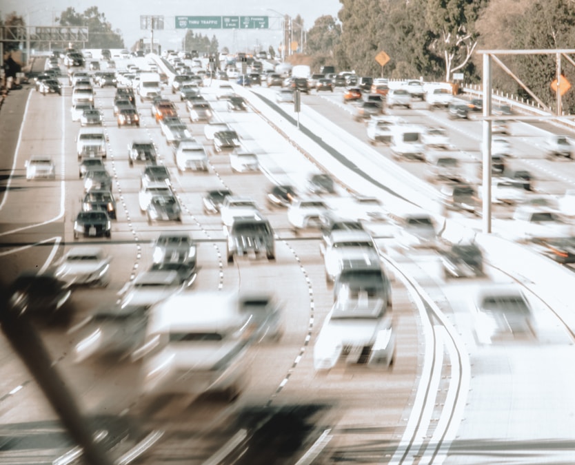 Blurred image of a busy highway with cars moving quickly in multiple lanes