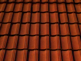 Close-up of textured terracotta roof tiles stacked neatly in sunlight.