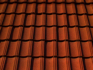 Close-up of a freshly installed terracotta roof with sunlight highlighting the texture.