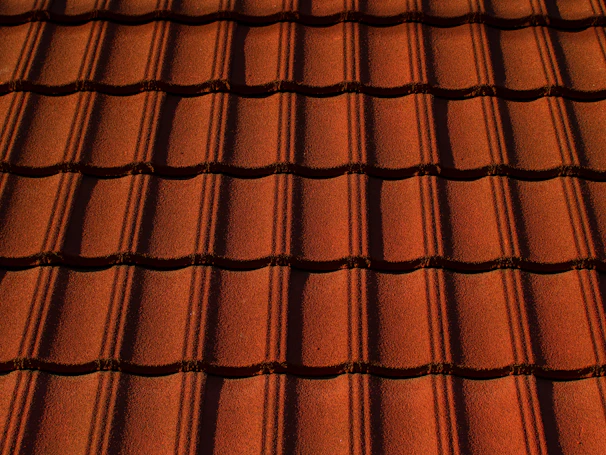 Close-up of a freshly installed terracotta roof with sunlight highlighting the texture.