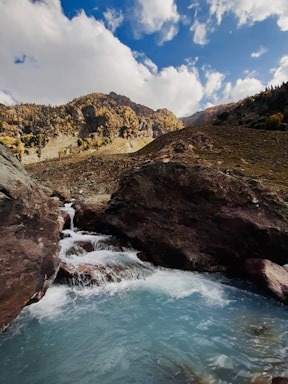 a river running through a valley surrounded by mountains