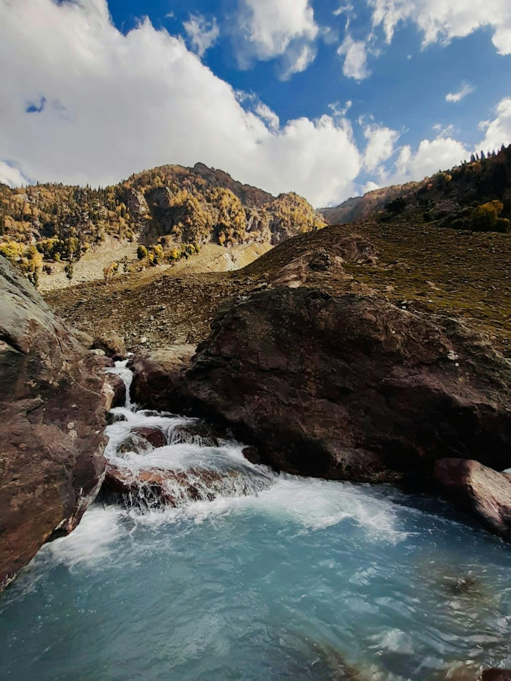 a river running through a valley surrounded by mountains