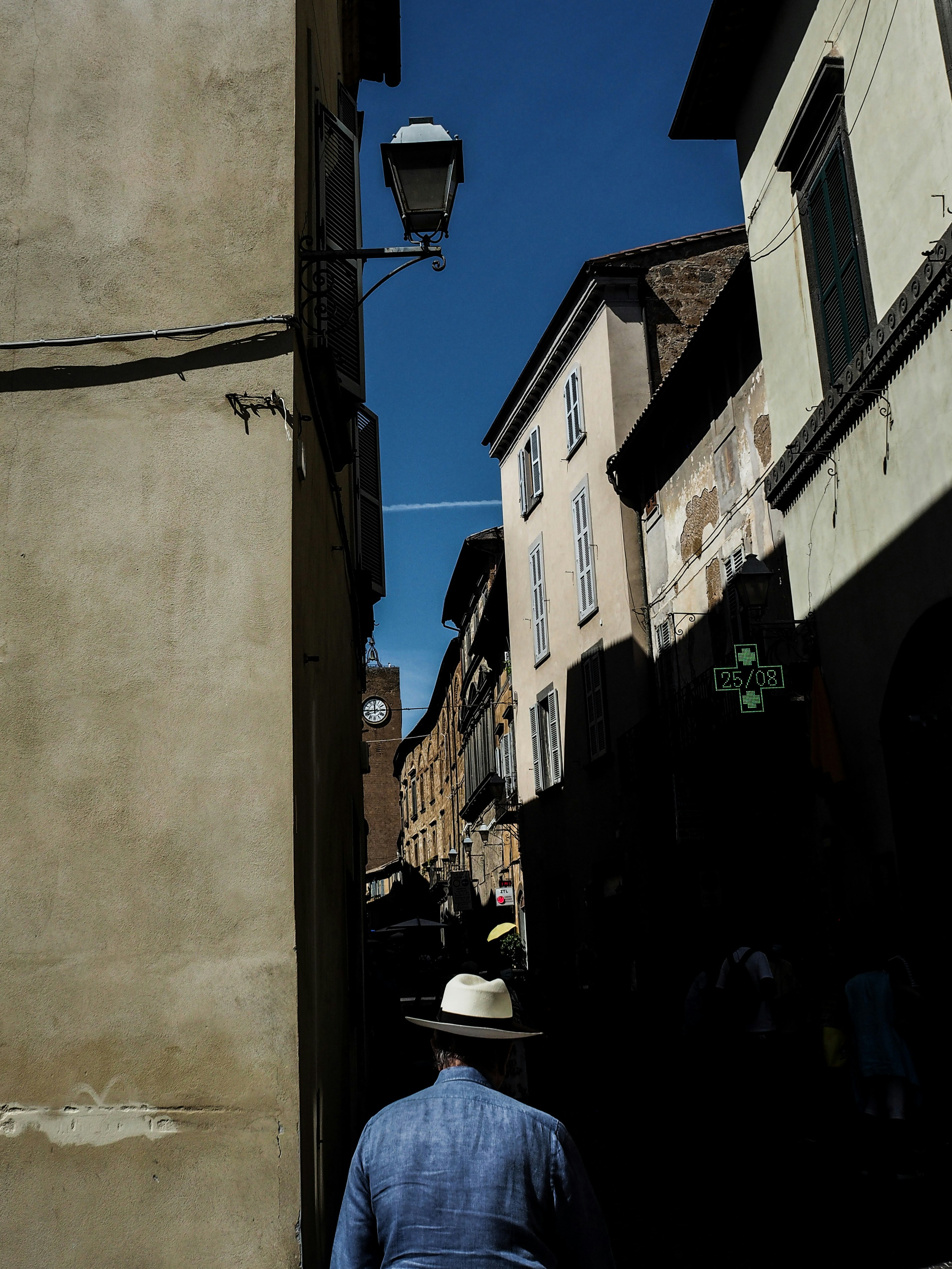 Ein Mann geht eine Straße neben hohen Gebäuden entlang