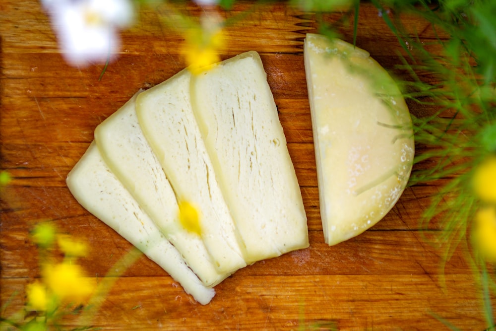 a wooden cutting board topped with sliced cheese