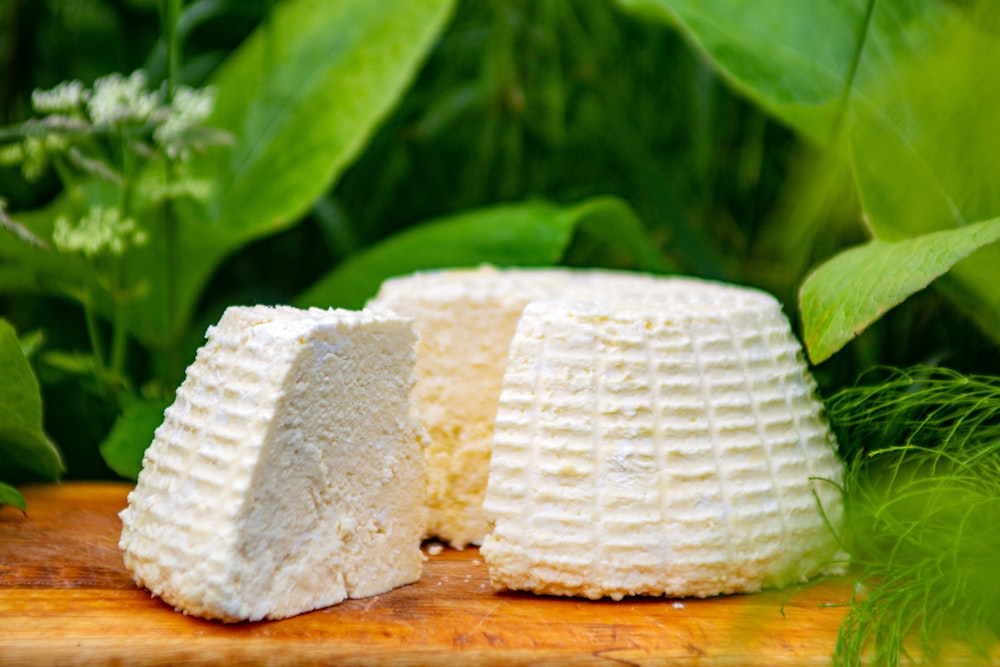 a piece of cheese sitting on top of a wooden cutting board