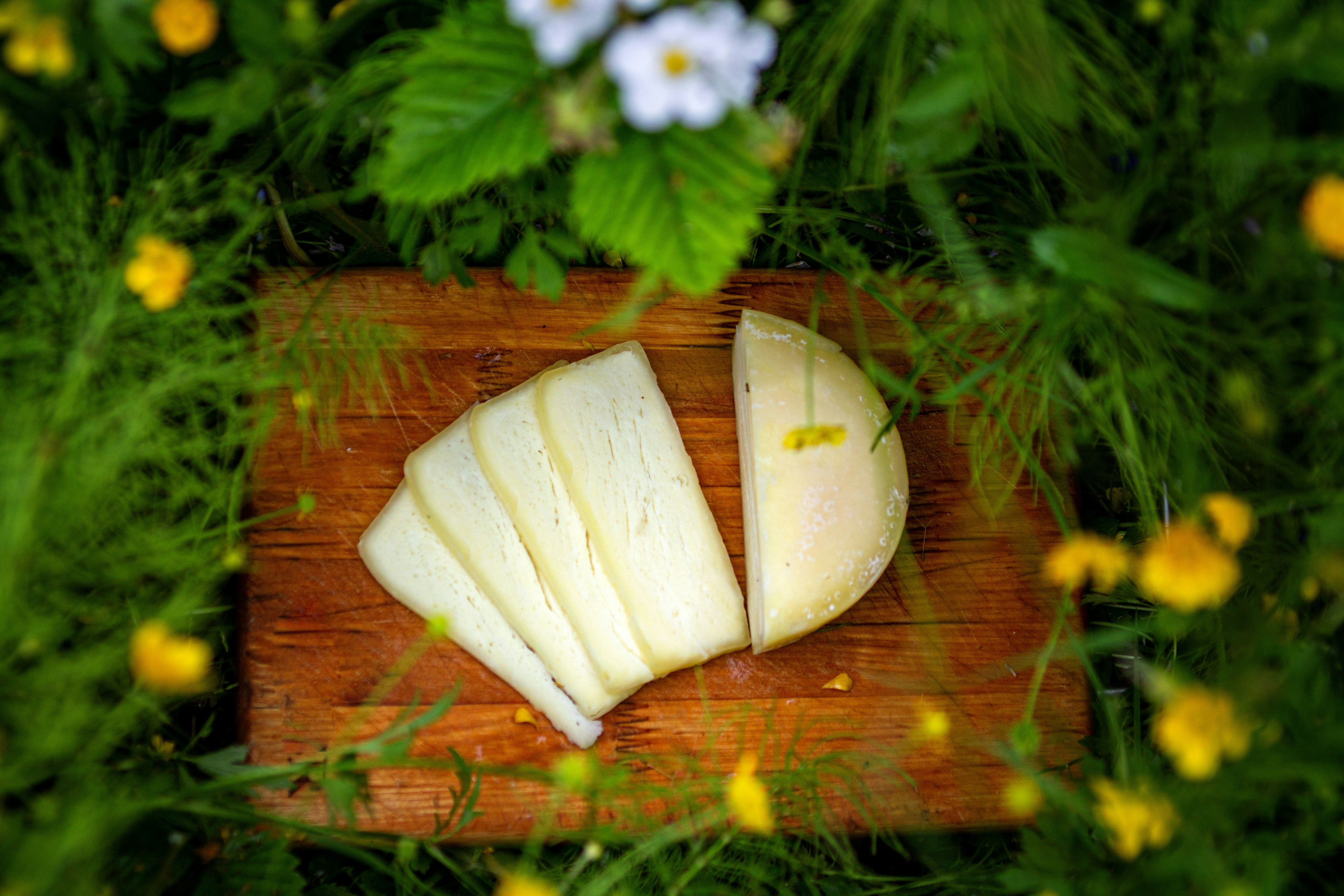 a wooden cutting board topped with slices of cheese