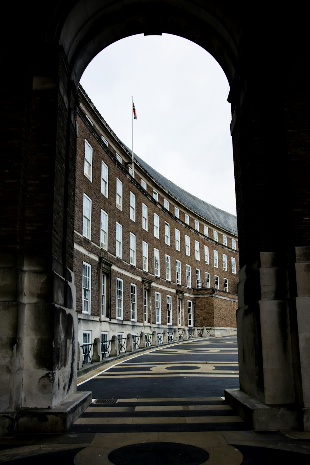 an archway leading to a building with a flag on top of it
