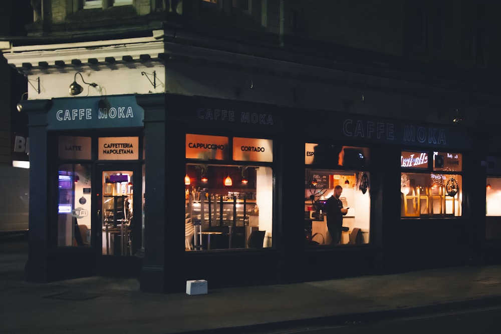 a store front at night with lit up windows