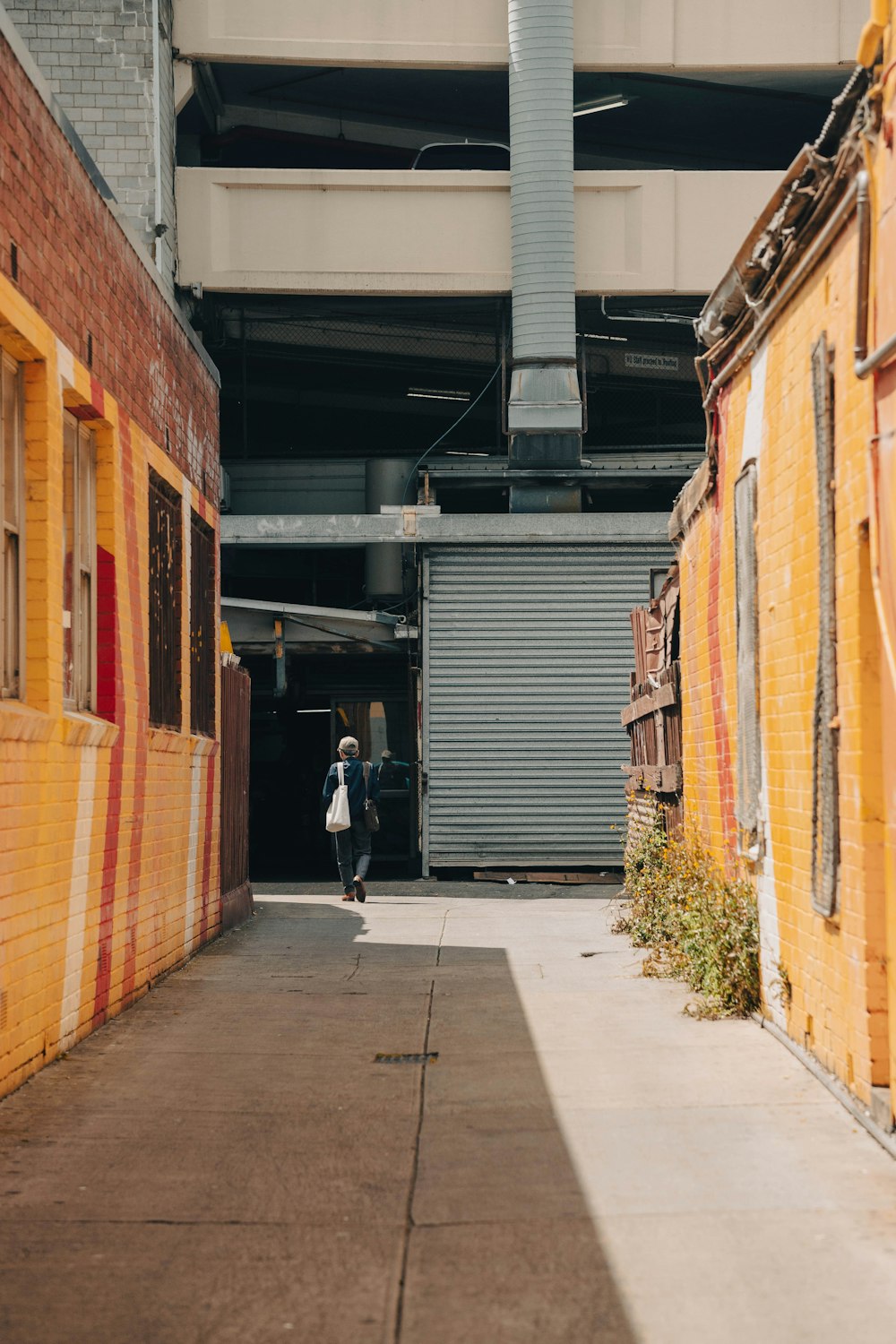 a person walking down a street next to a building