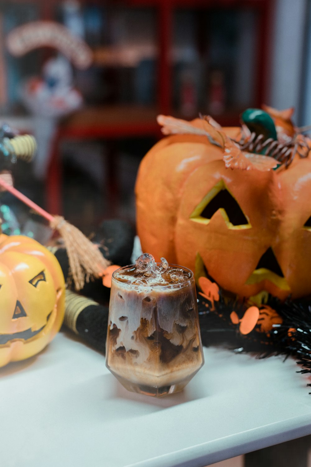 a table topped with two pumpkins and a drink