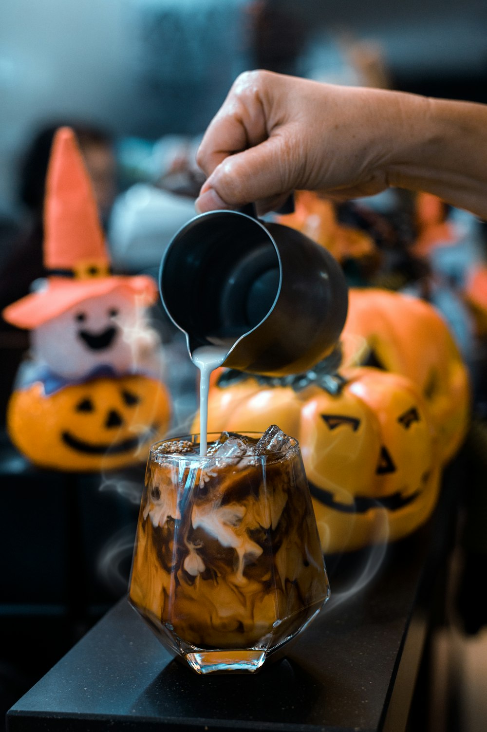 a person pouring something into a glass cup