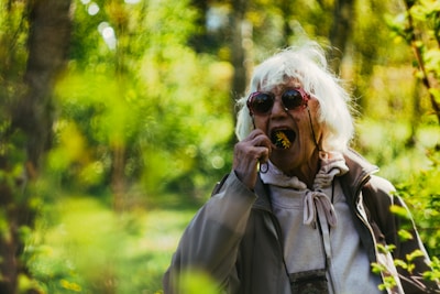 a woman with white hair and sunglasses talking on a cell phone