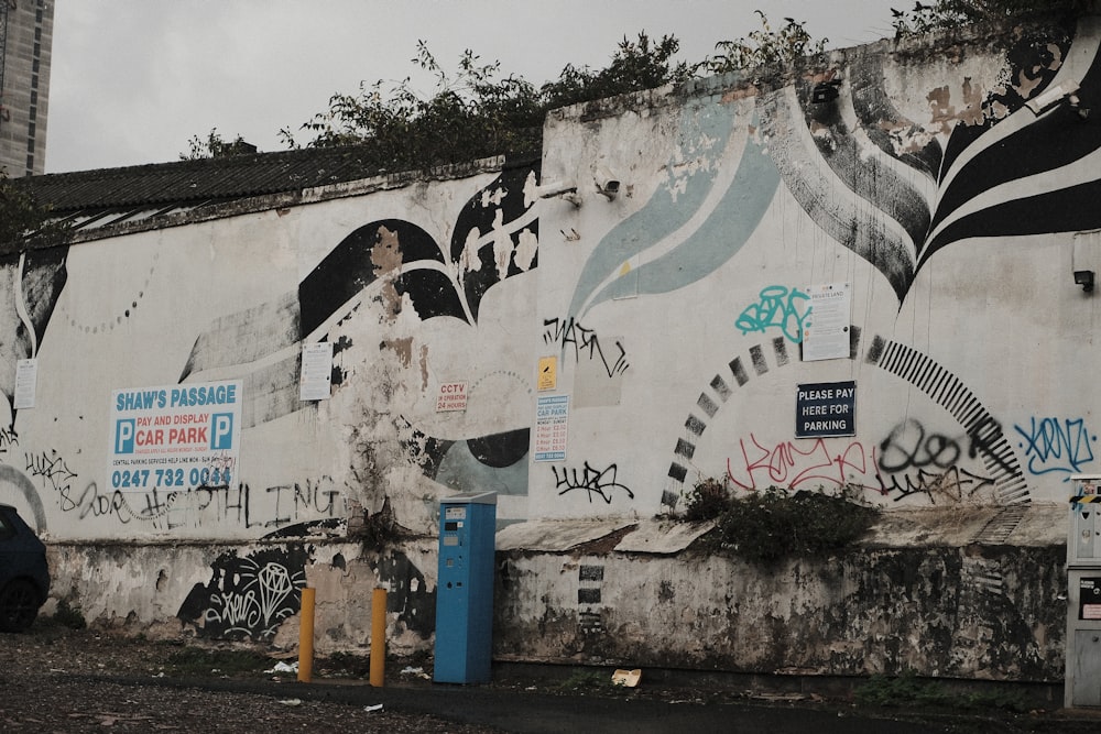 a wall covered in graffiti next to a parking meter