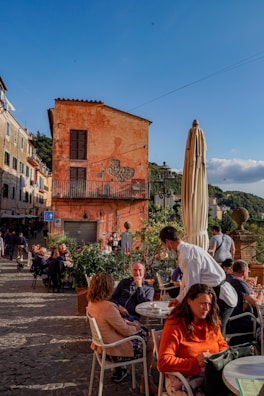 Guests enjoying their meals on a sunny terrace.
