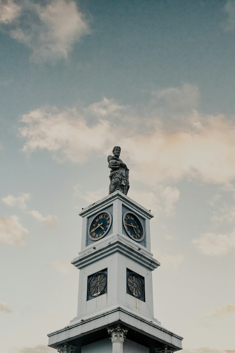 uma torre do relógio com uma estátua em cima dela