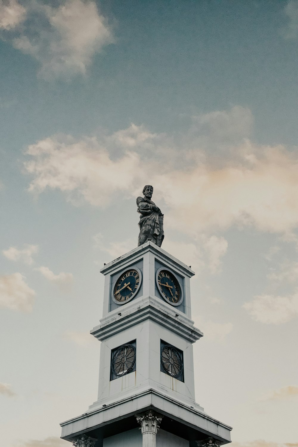 a clock tower with a statue on top of it