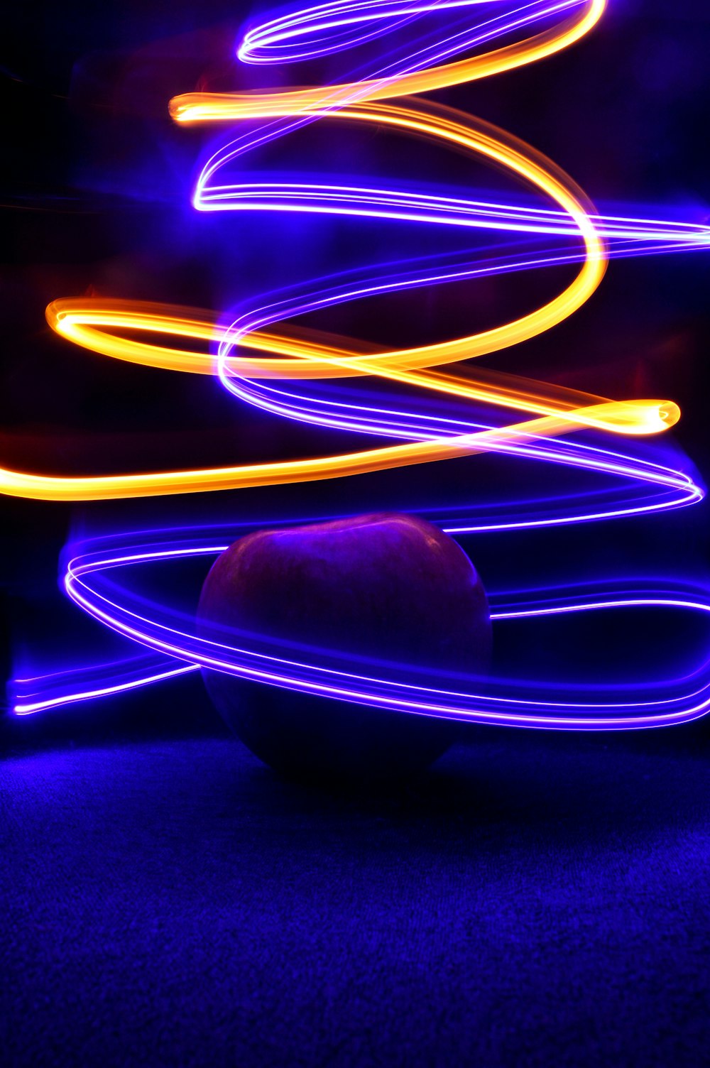 a fruit sitting on top of a table under a purple light