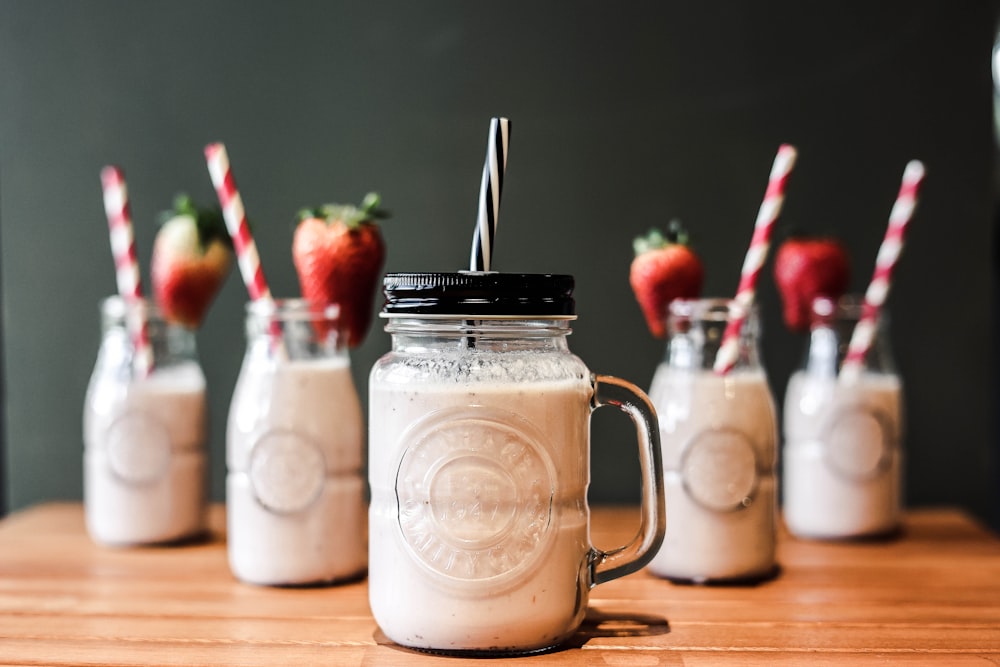 a group of mason jars with strawberries in them